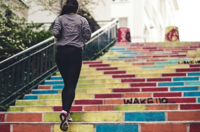 Person running up colorful stairs