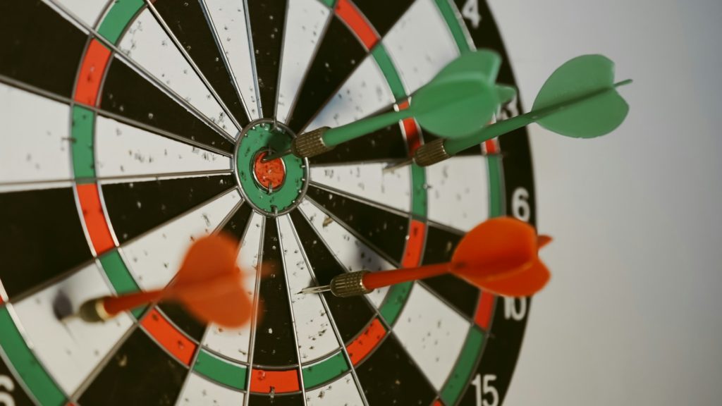 Dartboard with darts hitting bullseye