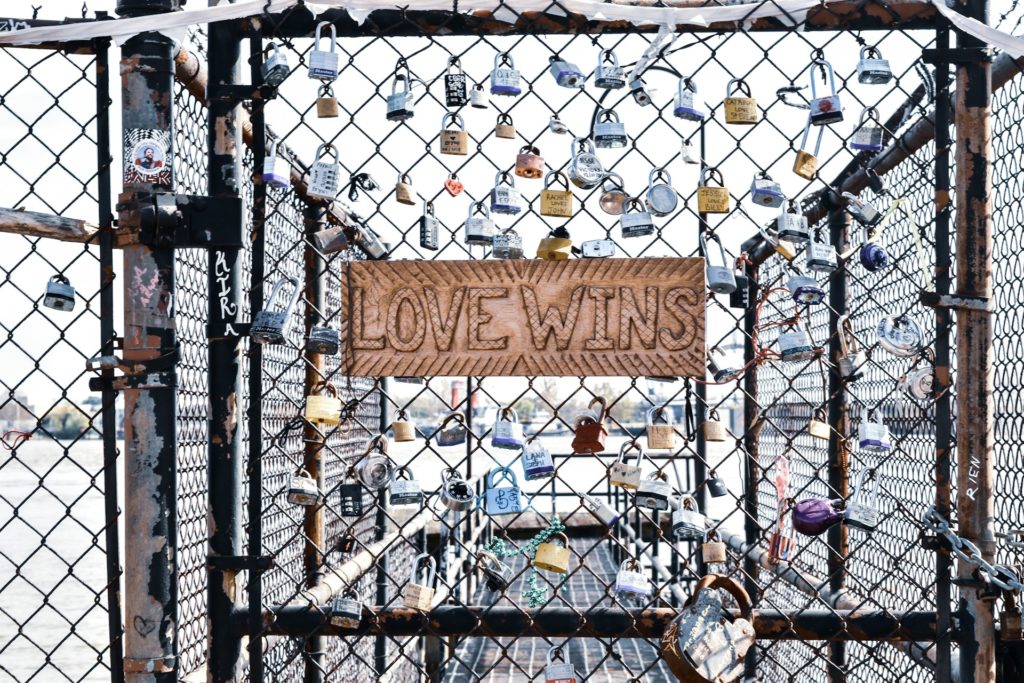 Love Wins sign with padlocks on fence