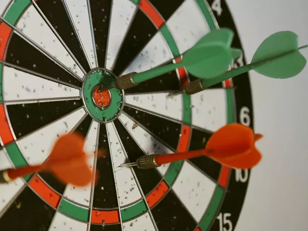 Darts hitting a dartboard bullseye