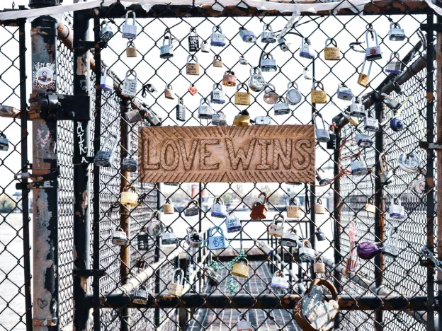 Love Wins sign on fence with locks.