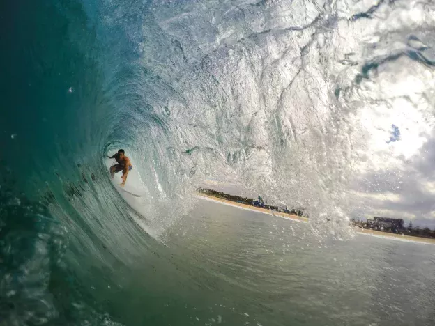 Surfer riding inside a powerful ocean wave.