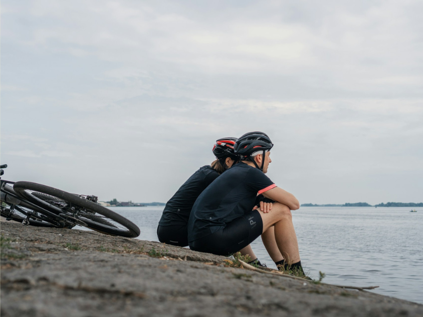 2 Cyclists resting by the lakeside.